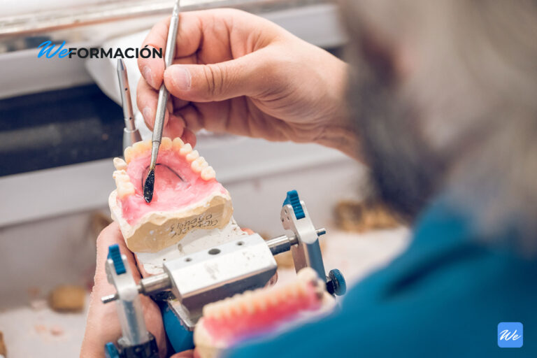Protésico dental modelando una prótesis removible sobre un articulador en el laboratorio