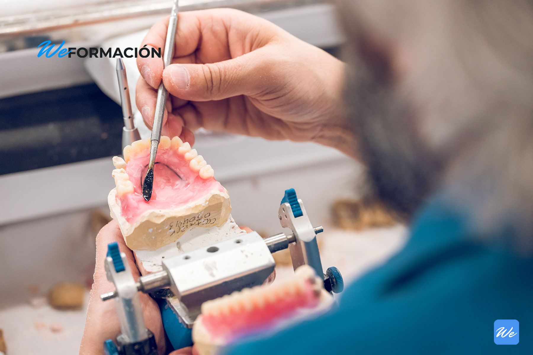 Protésico dental modelando una prótesis removible sobre un articulador en el laboratorio