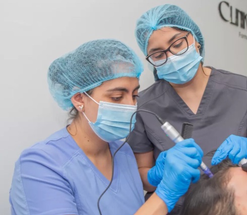 Medicina estética capilar y tricología: cabello, folículo piloso, fases de crecimiento y tratamientos capilares 2 Dos profesionales sanitarias realizando un tratamiento capilar a una paciente en consulta