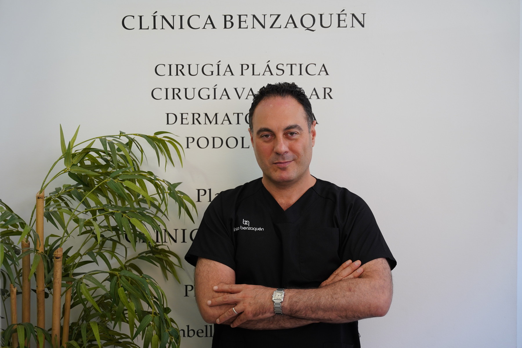 El Dr. Abraham Benzaquén, con uniforme clínico, ante el rótulo de Clínica Benzaquén